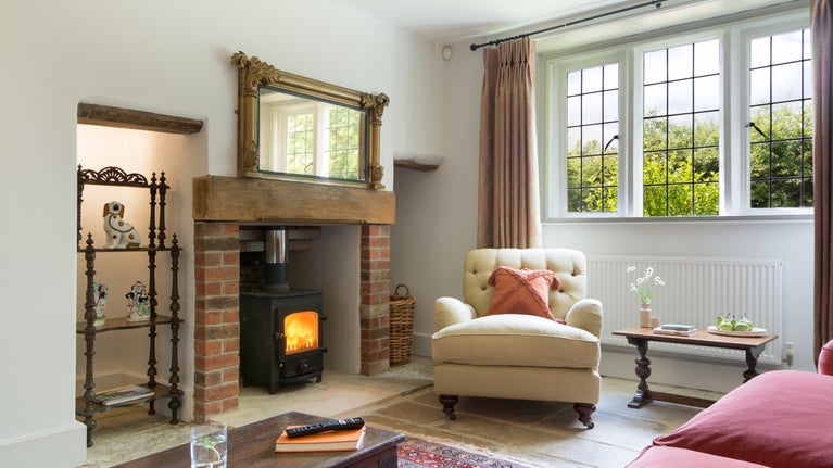 The sitting room with woodburner at Lyveden Cottage, Northamptonshire